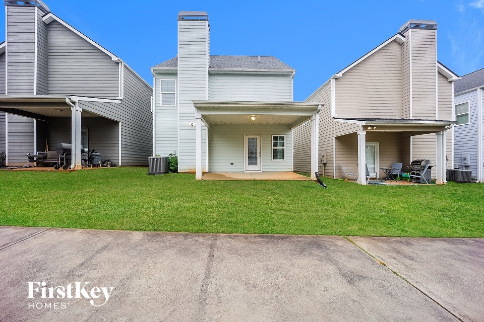 the backyard of a home with a lawn and a driveway