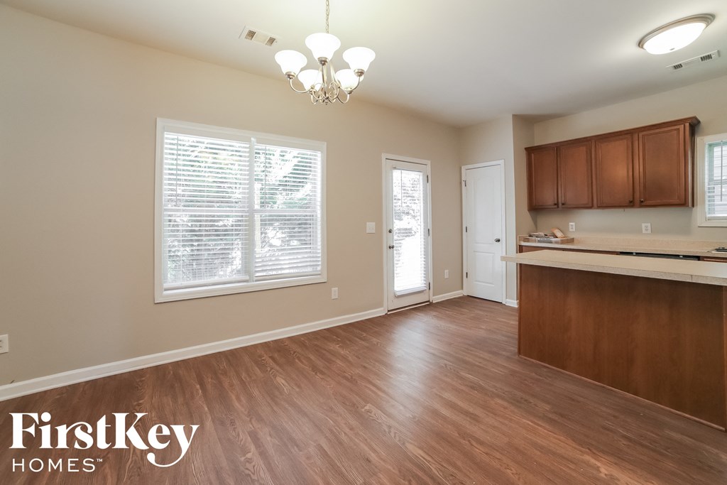 an empty kitchen and living room with wood flooring