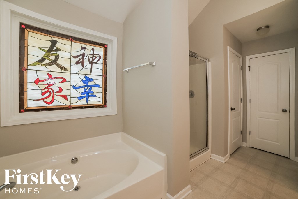 a bathroom with a large tub and a stained glass window