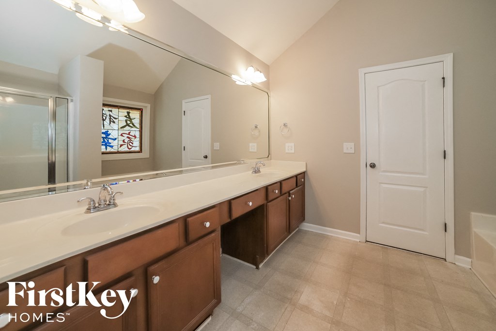 a large bathroom with a long counter top and a large mirror
