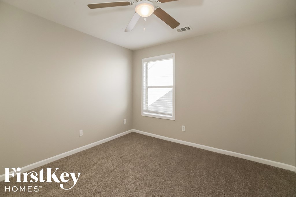 a bedroom with a ceiling fan and a window