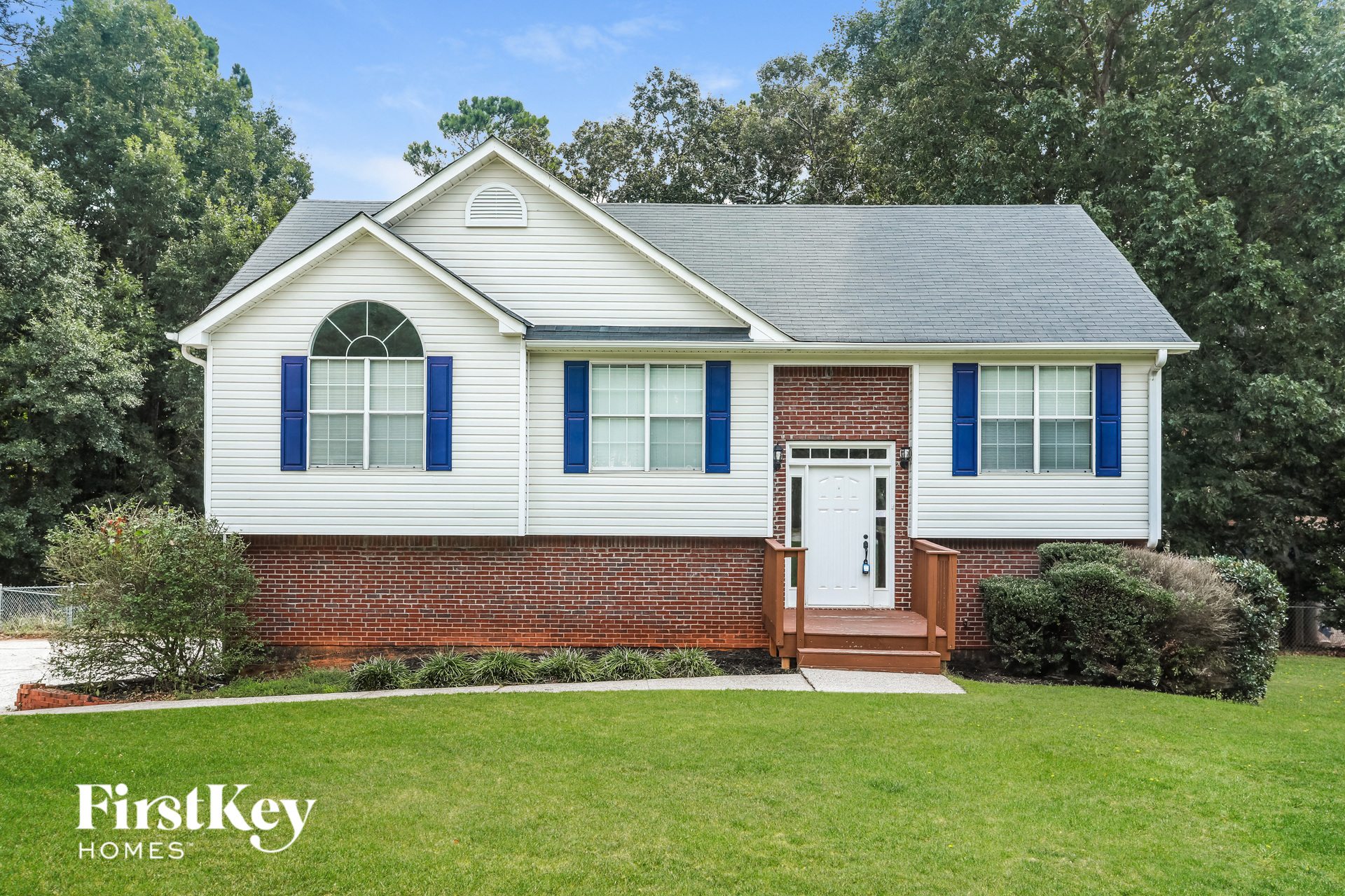 a white house with blue shutters and a lawn