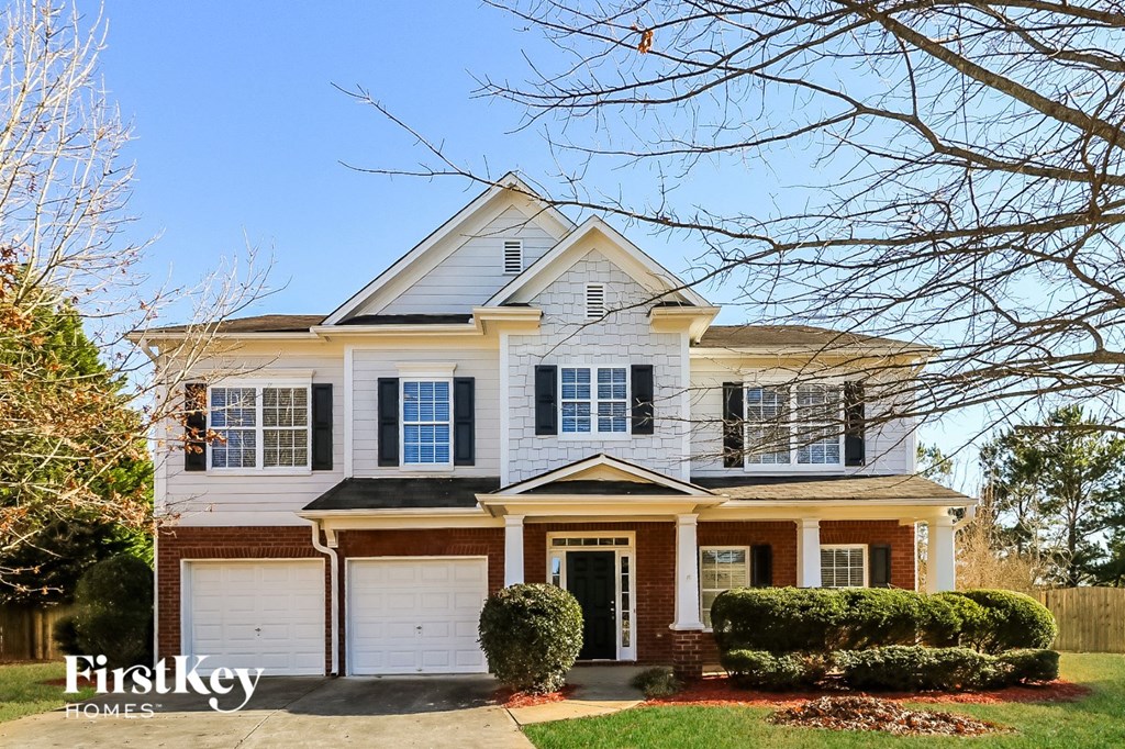 a white house with black shutters and a garage door