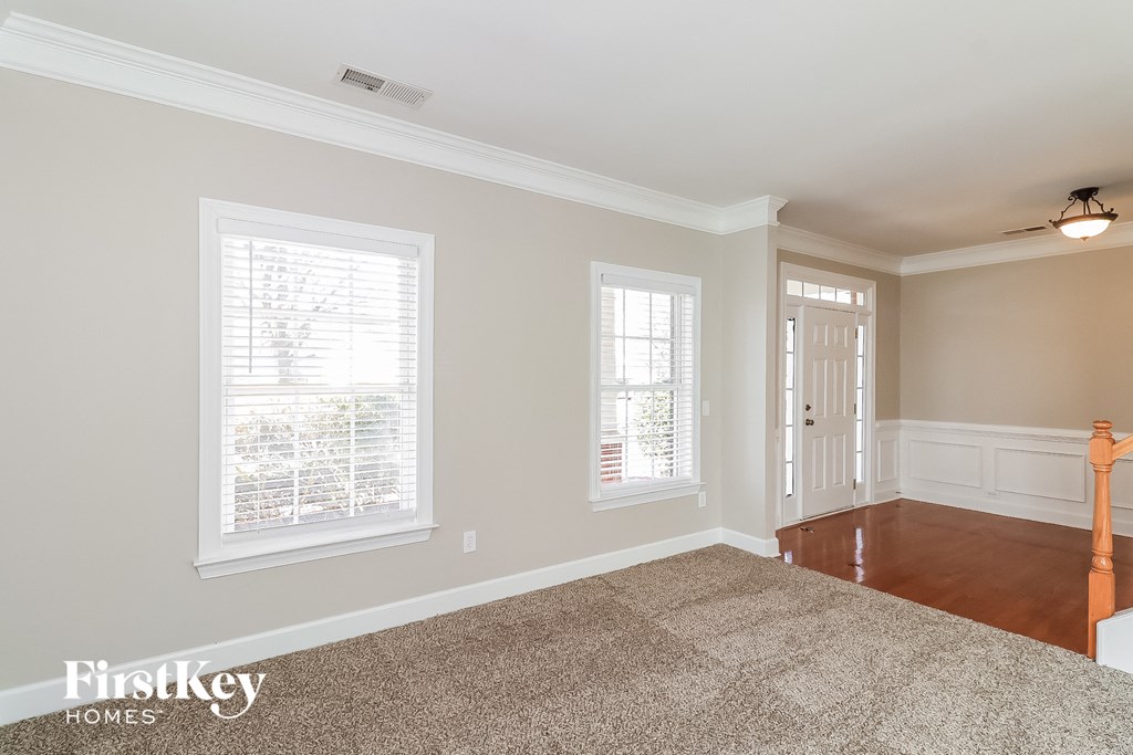 a living room with a carpet and a door to a hallway