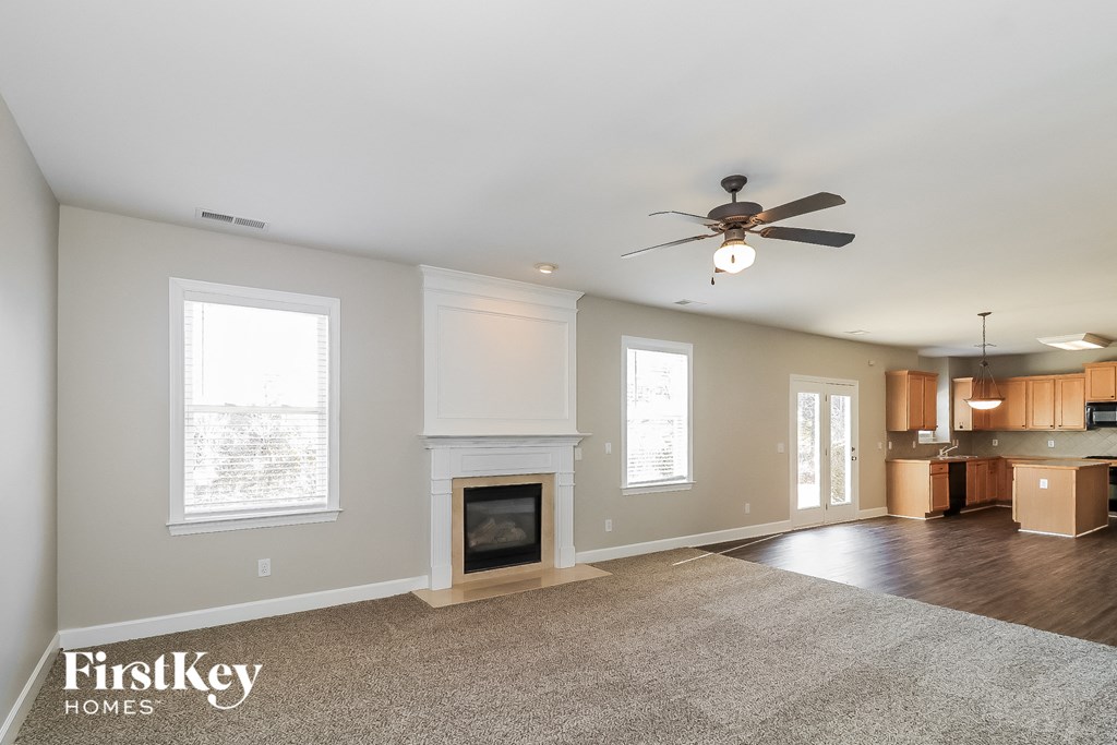 a living room with a fireplace and a ceiling fan