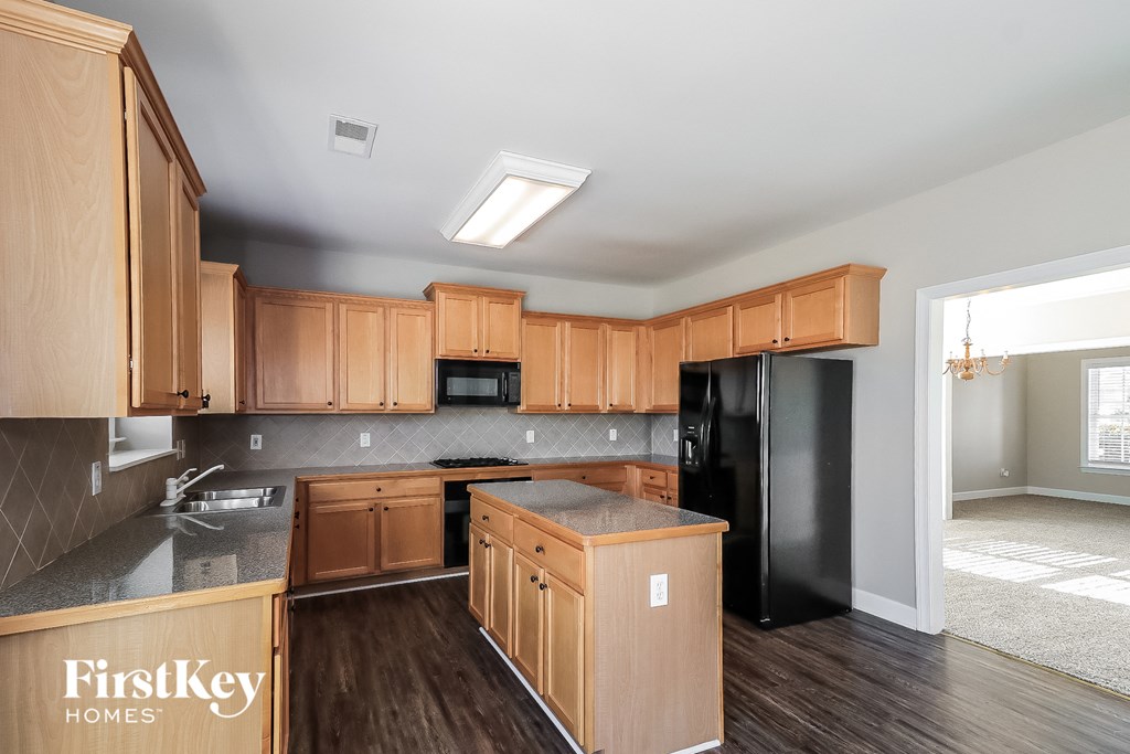 a kitchen with wooden cabinets and a black refrigerator