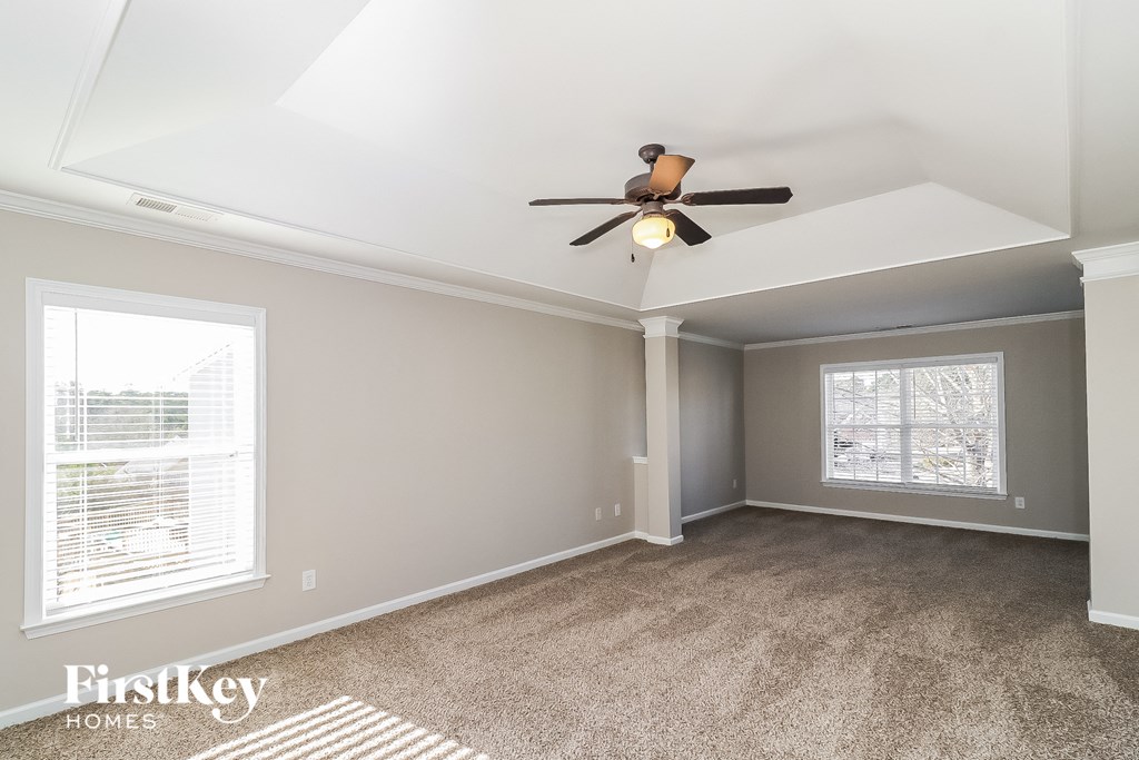 a living room with carpet and a ceiling fan