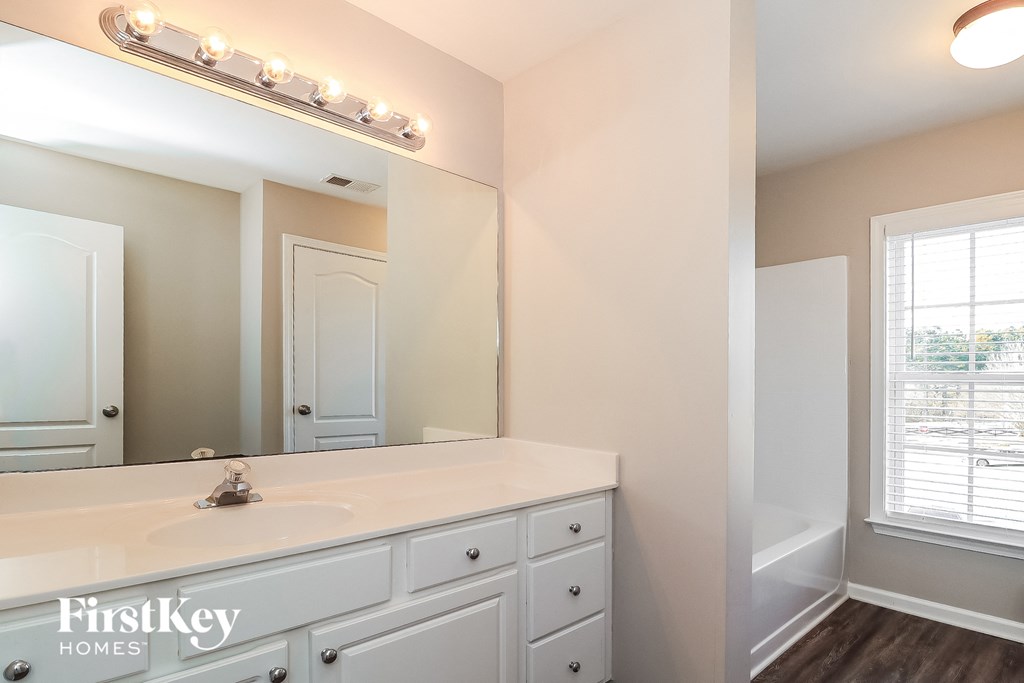 a bathroom with a large mirror and a white sink