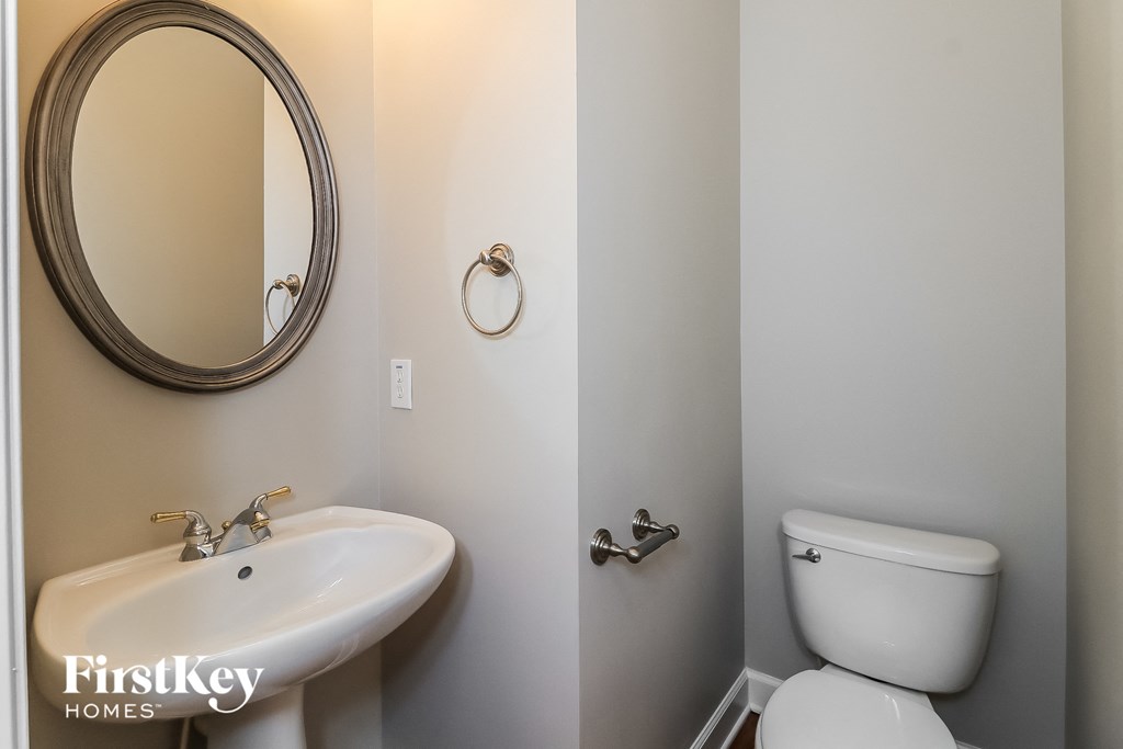a bathroom with a toilet and a sink and a mirror