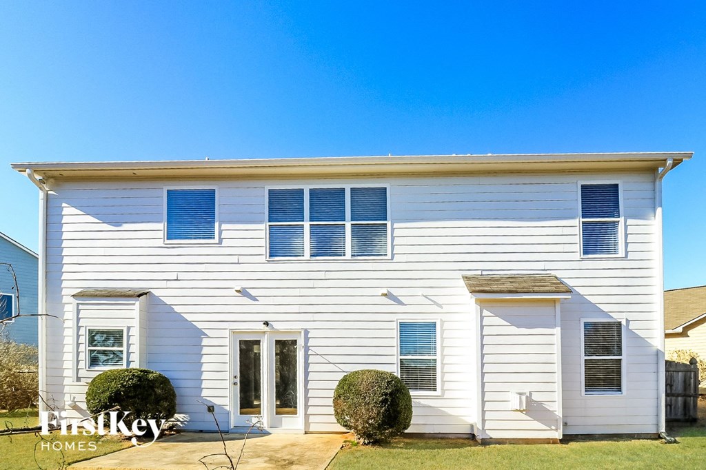 a white house with blue shutters and a blue sky