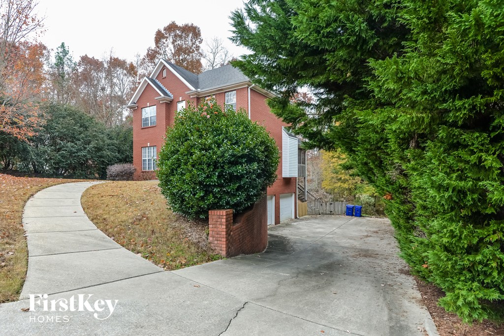 a brick house with a sidewalk in front of it