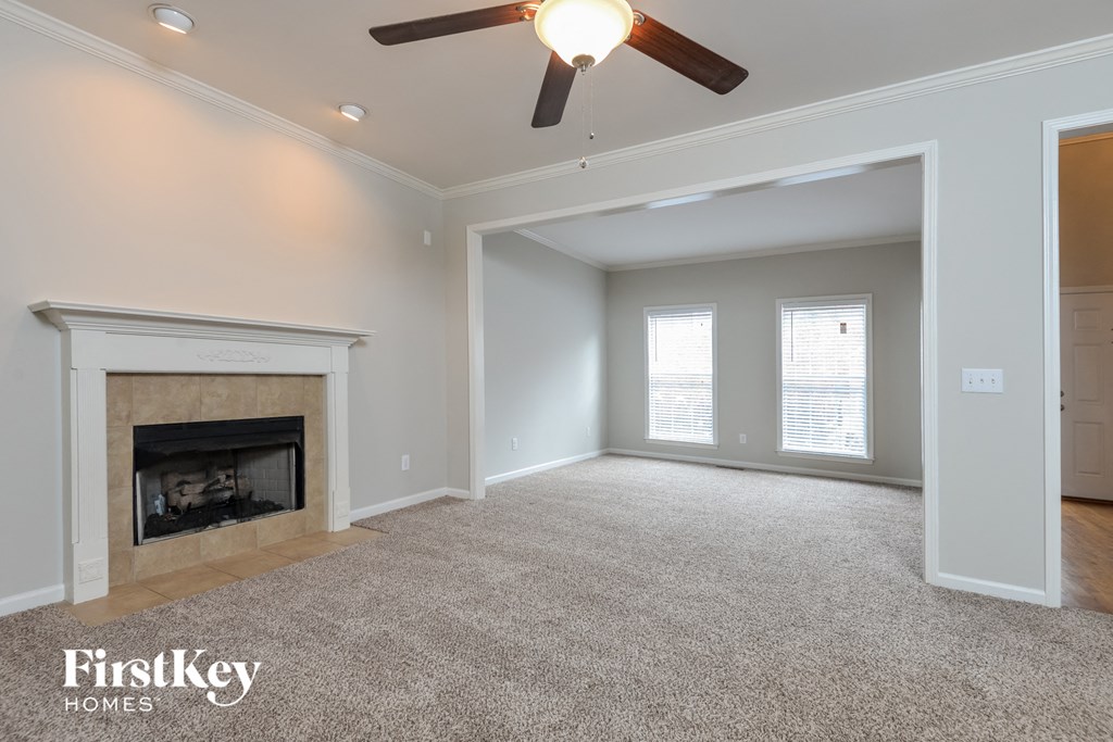 a living room with a fireplace and a ceiling fan