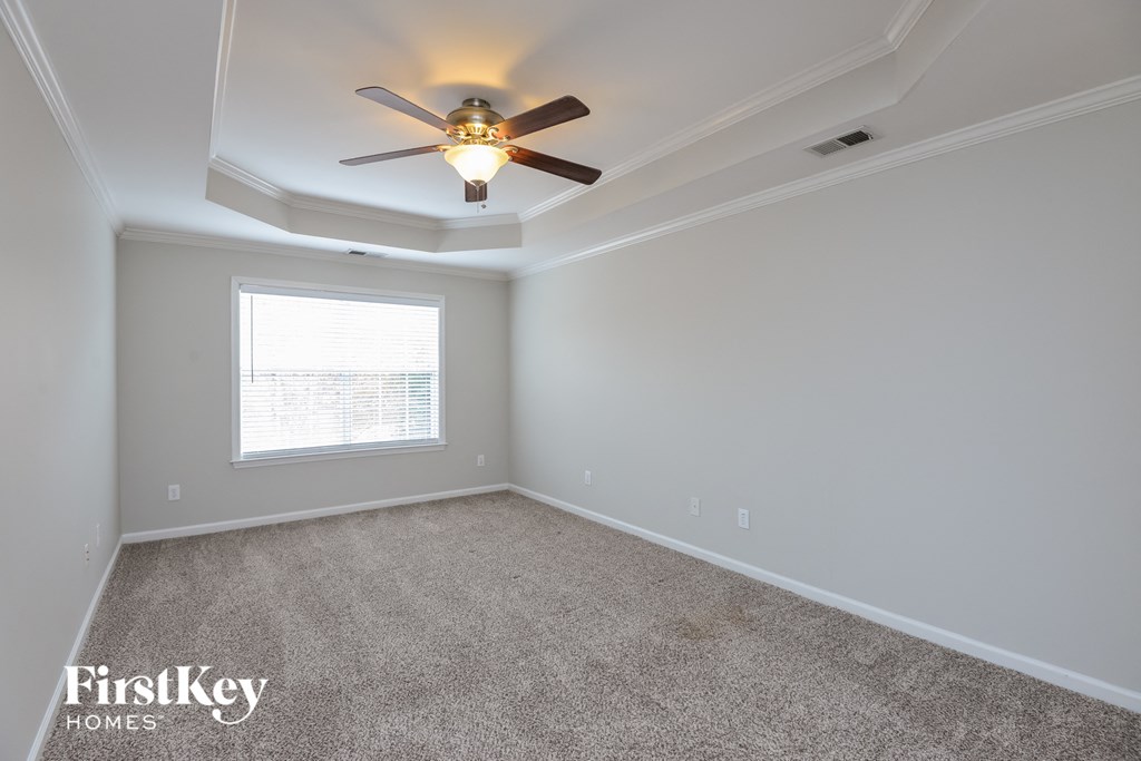 a bedroom with a ceiling fan and a window