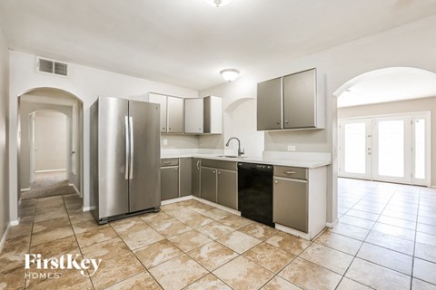a large kitchen with stainless steel appliances and tile flooring