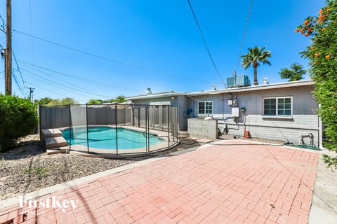 a backyard with a pool and a house with a fence