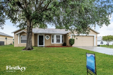 A house with a tree in front of it and a sign that says Firstkey Homes.