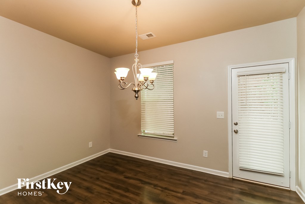 the living room of a house with a window and a chandelier