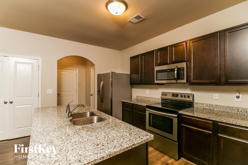 a kitchen with granite countertops and stainless steel appliances