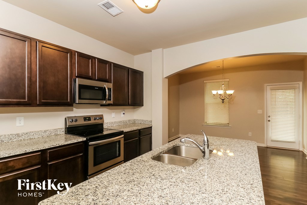 a kitchen with granite counter tops and wooden cabinets