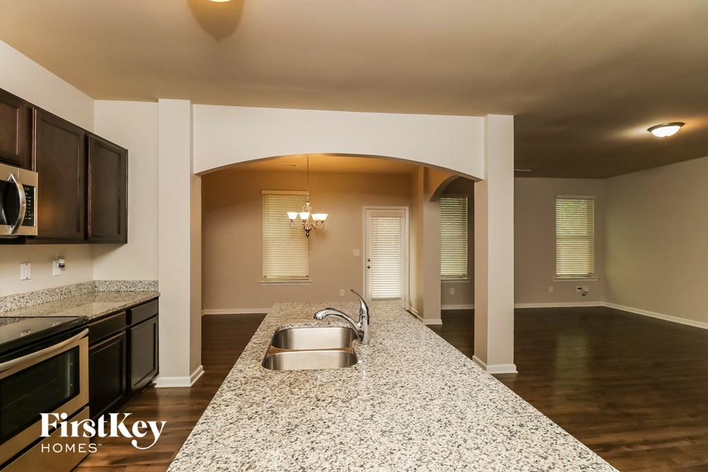 a kitchen with a sink and an empty living room