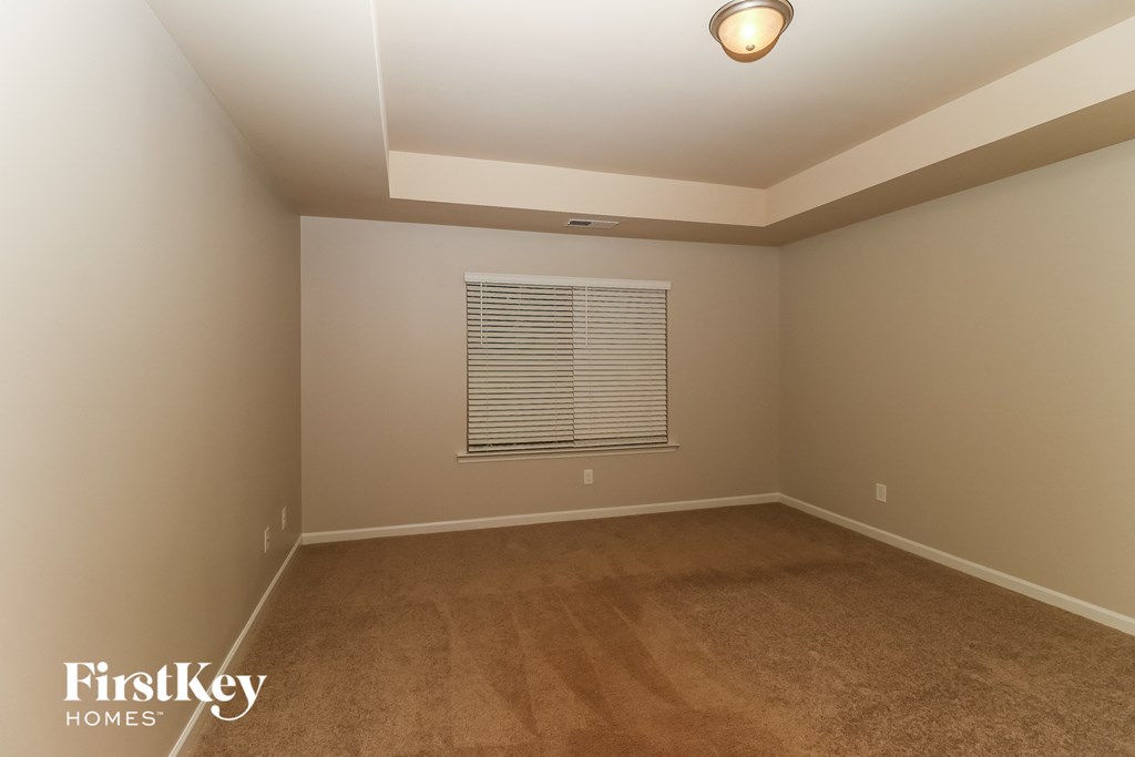 a empty room with carpet and a window