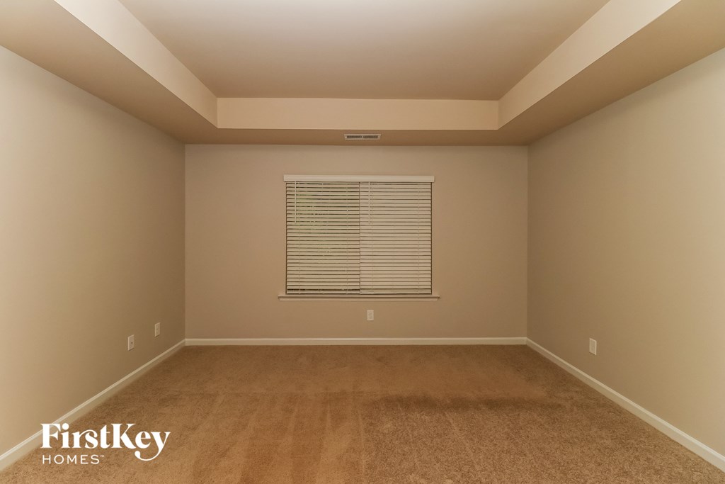 a empty room with carpet and a window