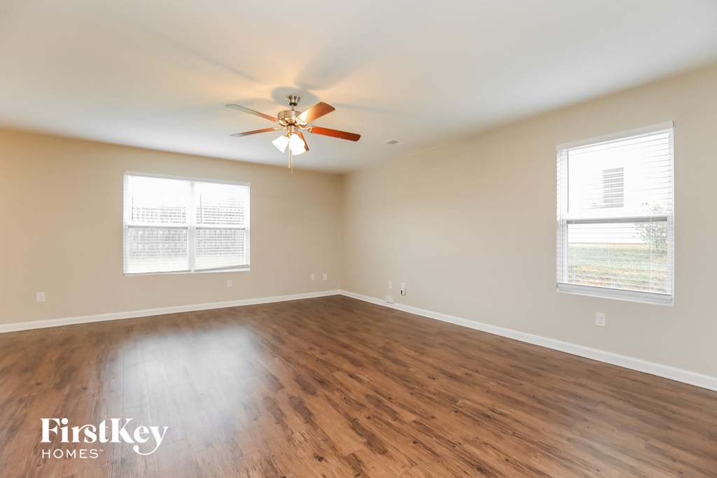 a living room with wood floors and a ceiling fan