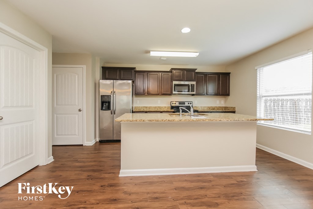 a kitchen with an island and a stainless steel refrigerator