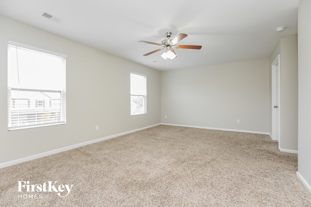 a bedroom with carpet and a ceiling fan