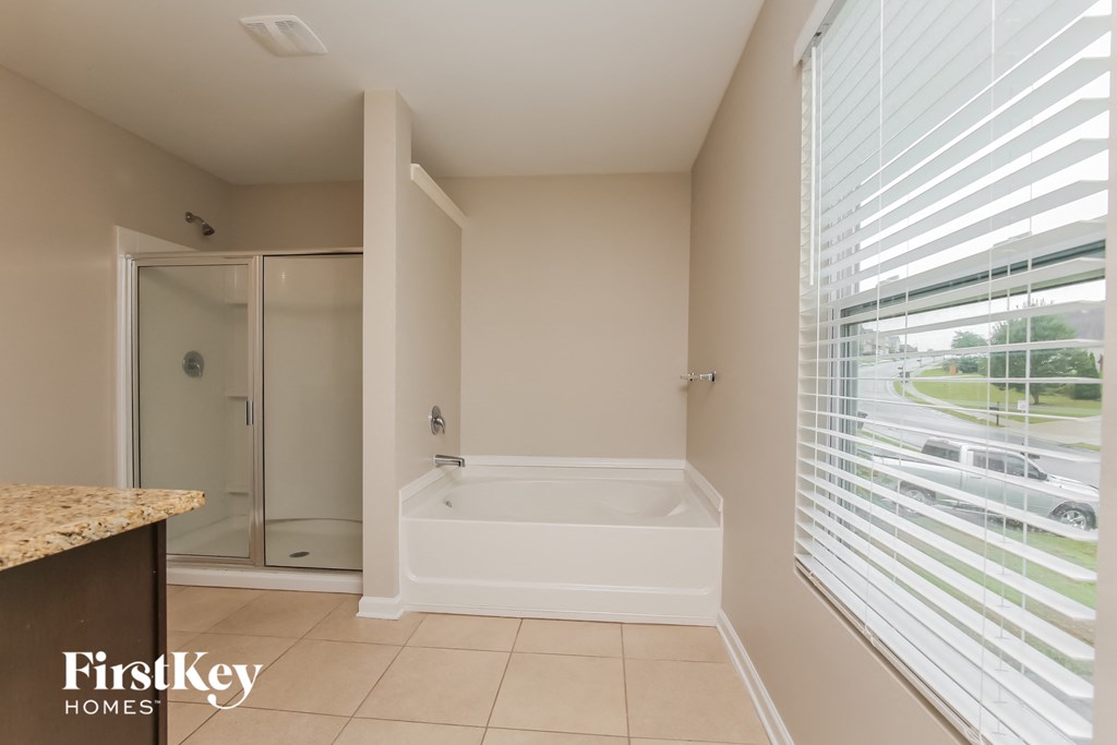 a bathroom with a tub and a shower and a large window