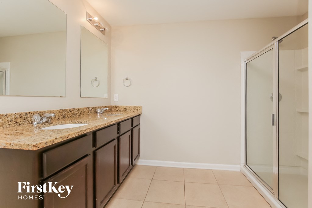 a bathroom with a sink and a shower and a mirror