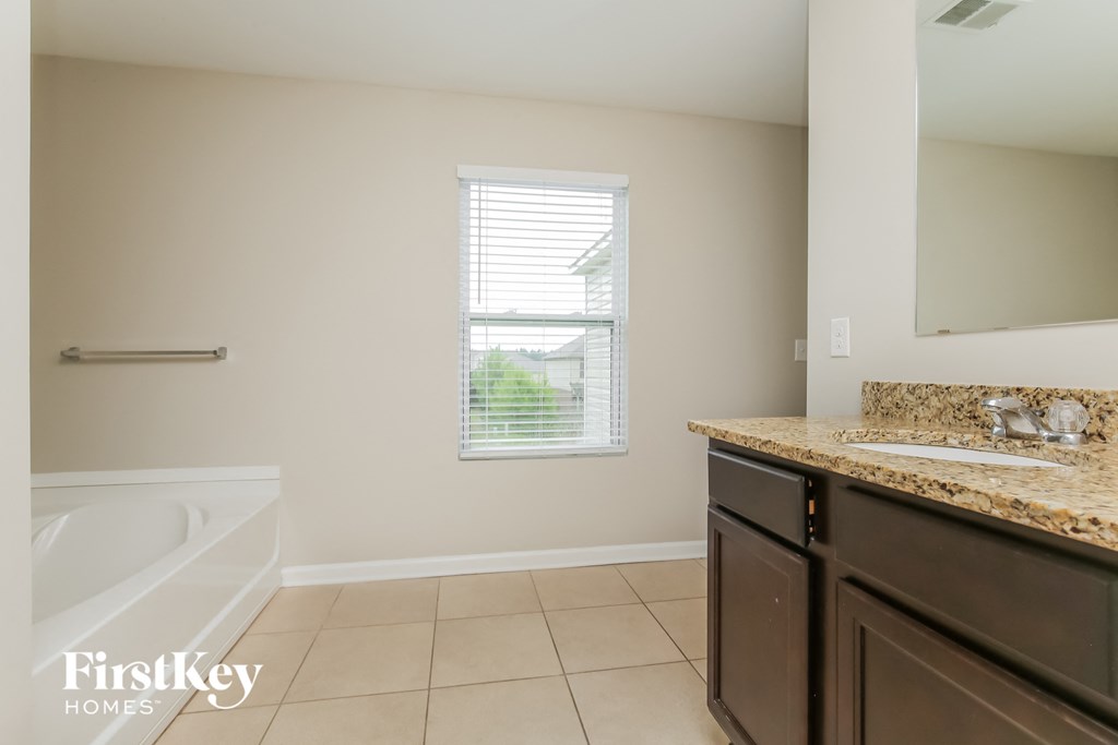 a bathroom with a sink and a bath tub and a mirror