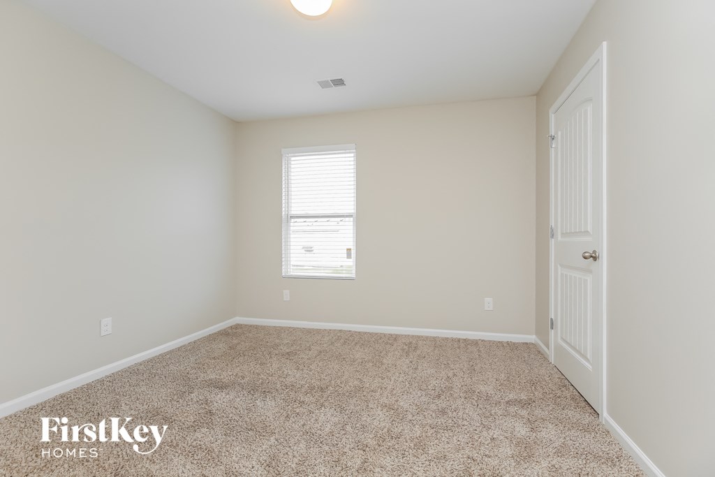 a bedroom with a carpeted floor and a white door