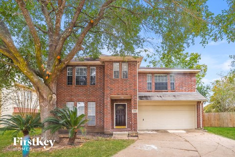 a brick house with a tree in front of it
