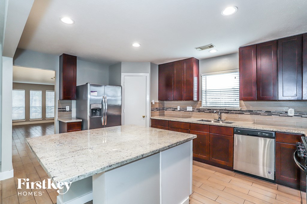 a kitchen with stainless steel appliances and a marble counter top