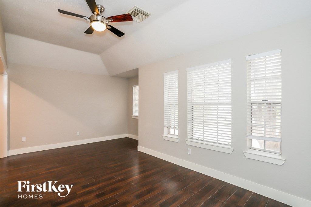 a living room with wood floors and a ceiling fan