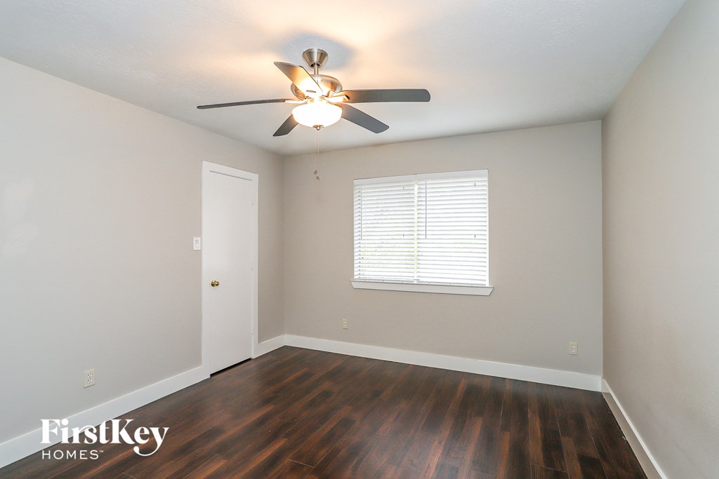 a bedroom with hardwood flooring and a ceiling fan