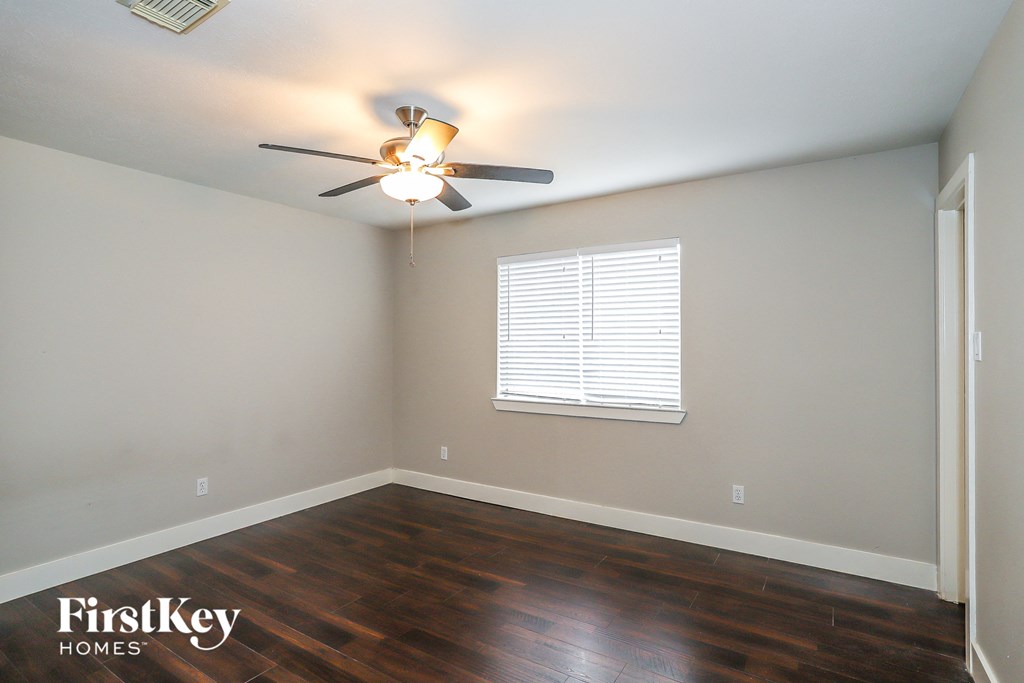 a empty room with a ceiling fan and a window