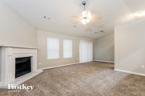 a living room with a fireplace and a carpeted floor
