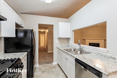 a kitchen with white cabinets and a sink and a refrigerator