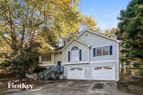 a white house with a white garage and trees