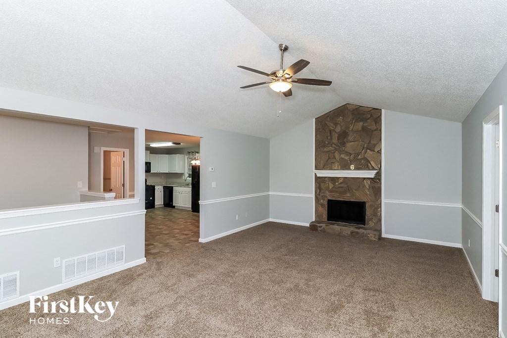 a living room with a fireplace and a ceiling fan