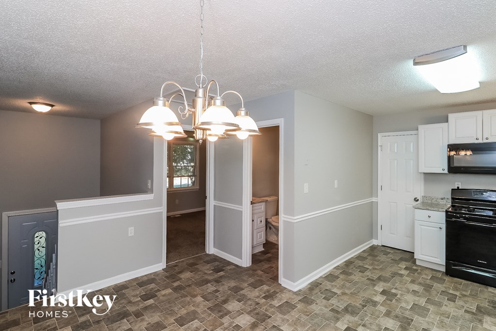 a kitchen and dining room with white cabinets and a tile floor