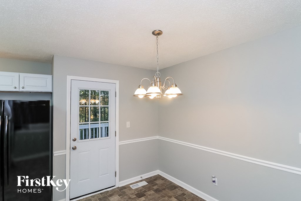 a dining room with a white door and a chandelier