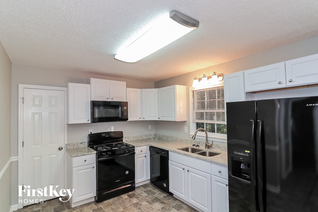 a kitchen with black appliances and white cabinets