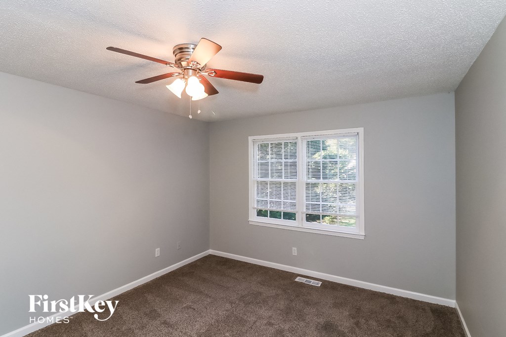 a bedroom with a ceiling fan and a window