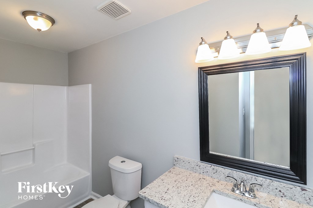a bathroom with a mirror and a sink and a toilet
