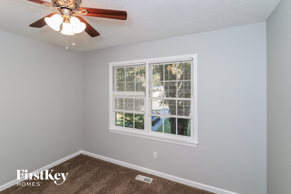 a bedroom with a ceiling fan and a window