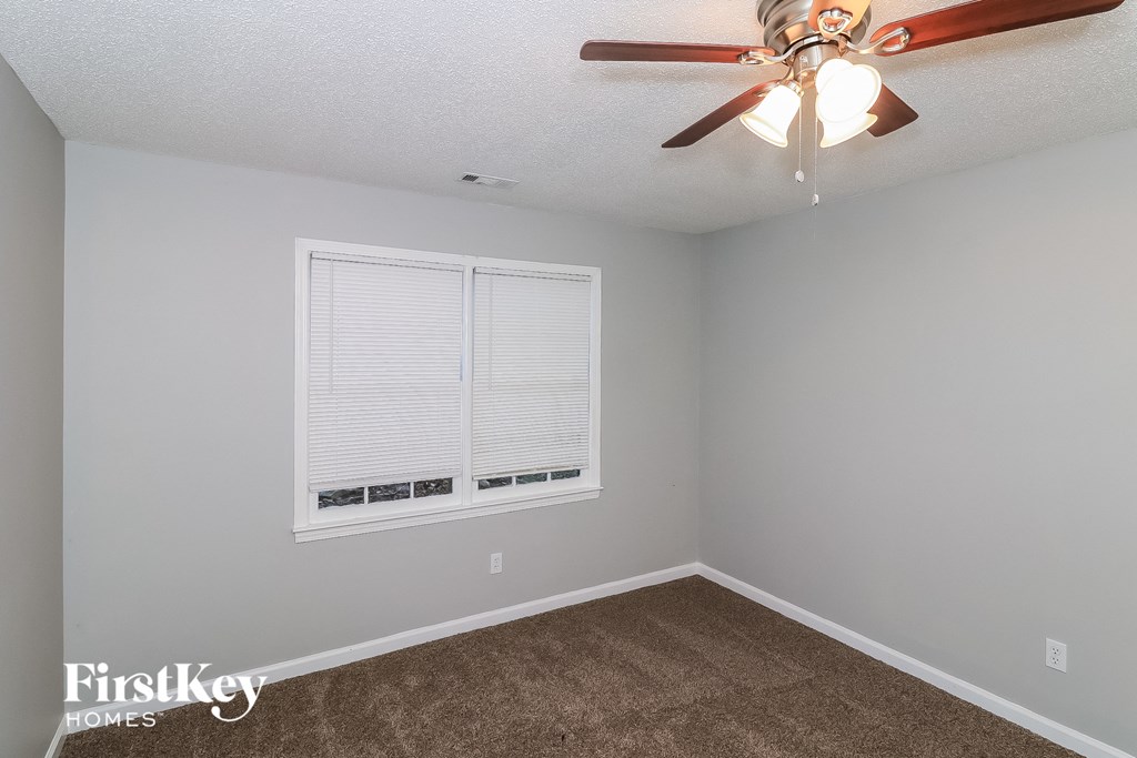 a bedroom with a ceiling fan and a window