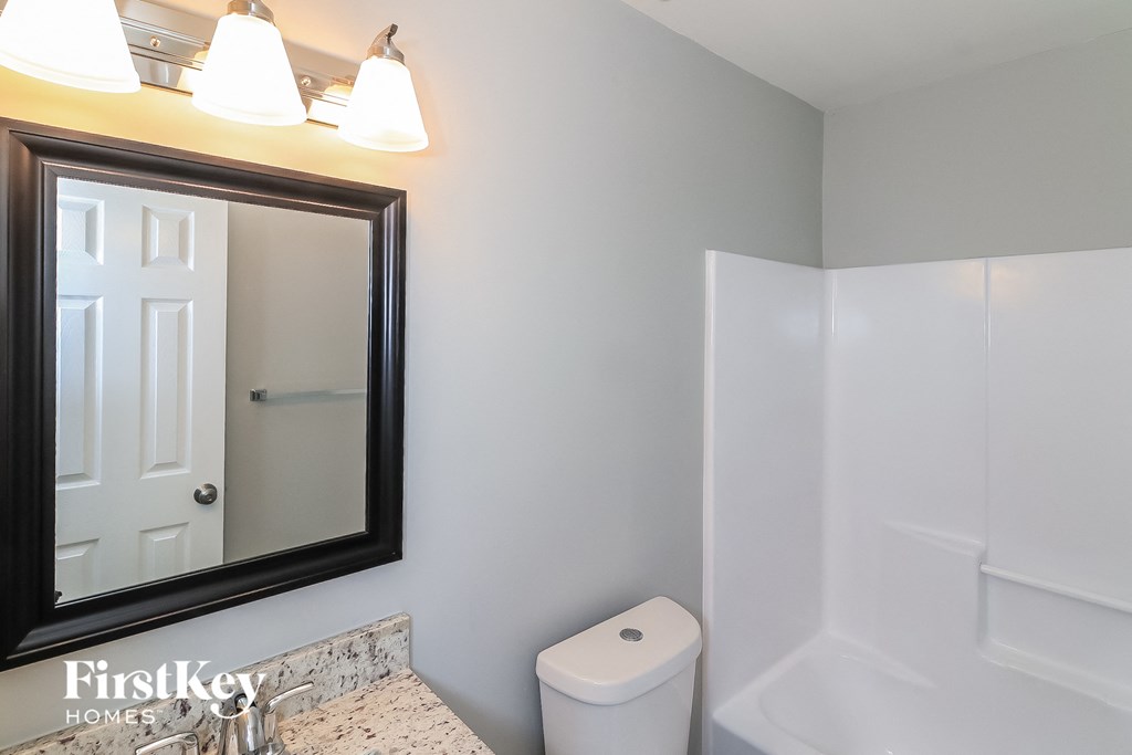 a small bathroom with a mirror and a toilet and a shower